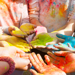 A picture of 6 pairs of hands in a circle, the hands have all been painted different colors.