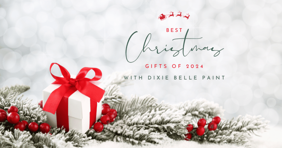 a white present with red ribbon, red berries and green pine needles sitting on a table top, the words Best Christmas Gifts of 2024 with Dixie Belle Paint is printed above the gift in front of a white sparkly background