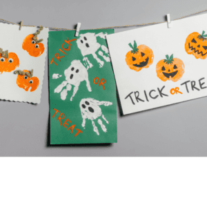 Hand painted children's Halloween paintings hanging on a clothes line.