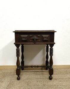 "Before" photo of brown wooden nightstand sitting on a brown woven rug in front of a white wall