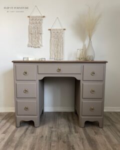 A desk painted with Badlands Silk All-In-One Mineral Paint sits on a brown wooden floor, in front of a white painted wall