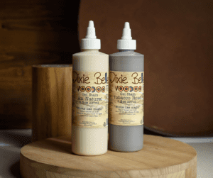 Bottles of Au Naturel and Tobacco Road Voodoo Gel Stain sitting on a circular wooden platform