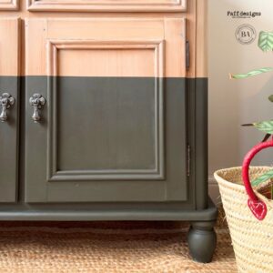 Lower right corner of buffet with Fireside Ash Voodoo Gel Stain on top and Collard Greens Chalk Mineral Paint on the bottom of the buffet sitting on a brown rug with a basket to the right of the buffet.