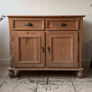 "Before" picture of wooden buffet sitting on a wooden floor